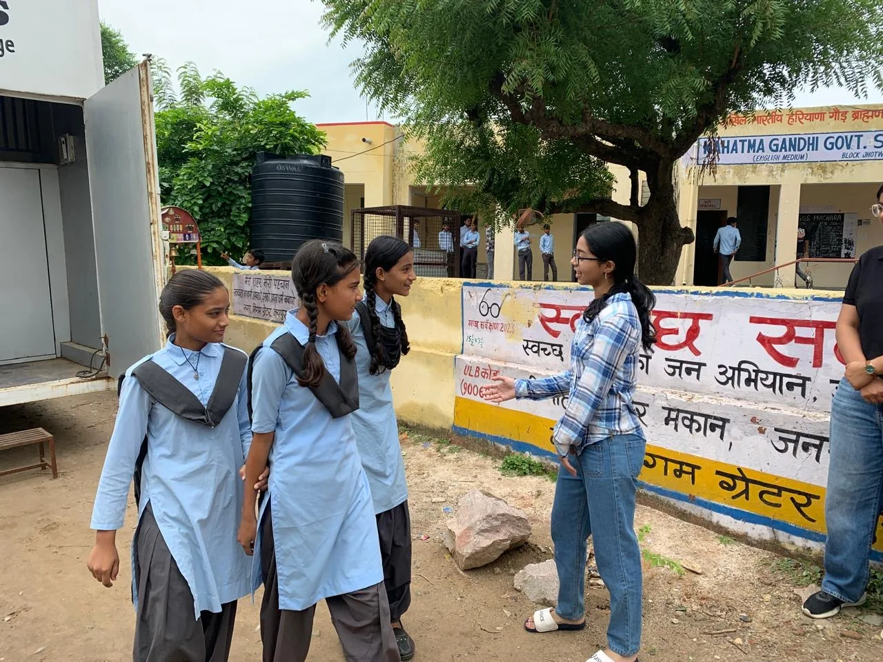 Myra Jhawar speaking with students in a school courtyard