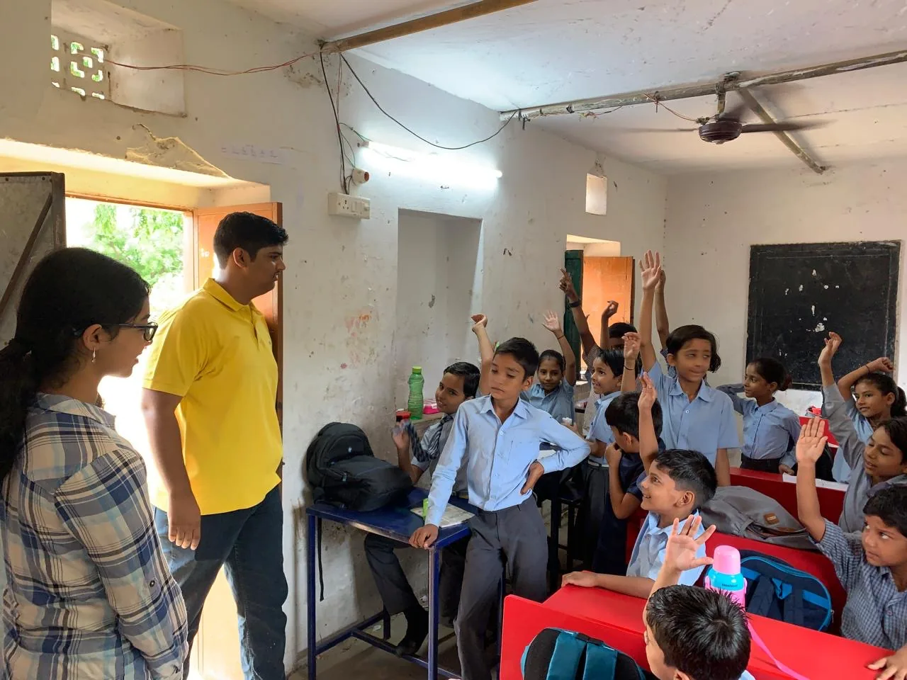Volunteers talking with students in a classroom