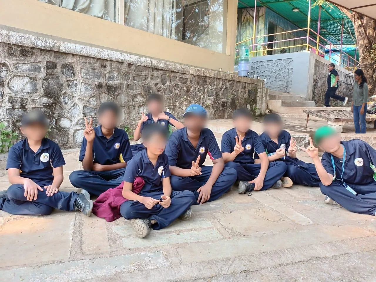 Students sitting together outdoors at TABIS, faces blurred